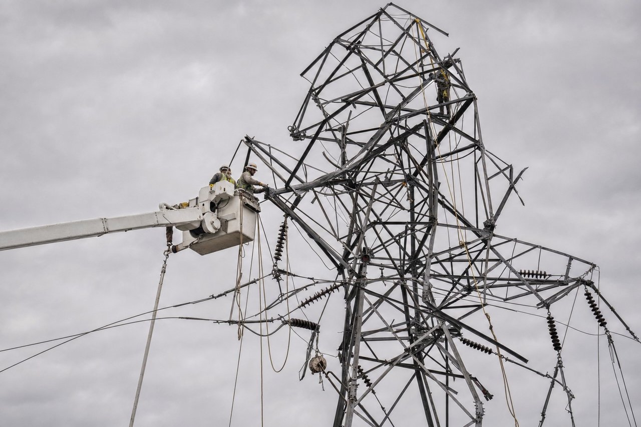 A utility line crew repairing a damaged transmission tower against an overcast sky after a storm (AI-generated image)