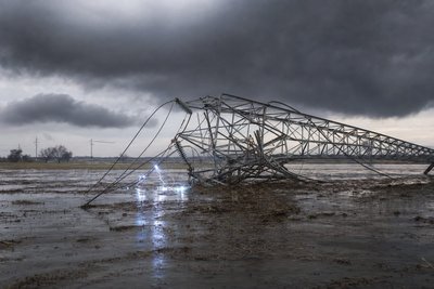 Electrical transmission towers over a storm-damaged landscape